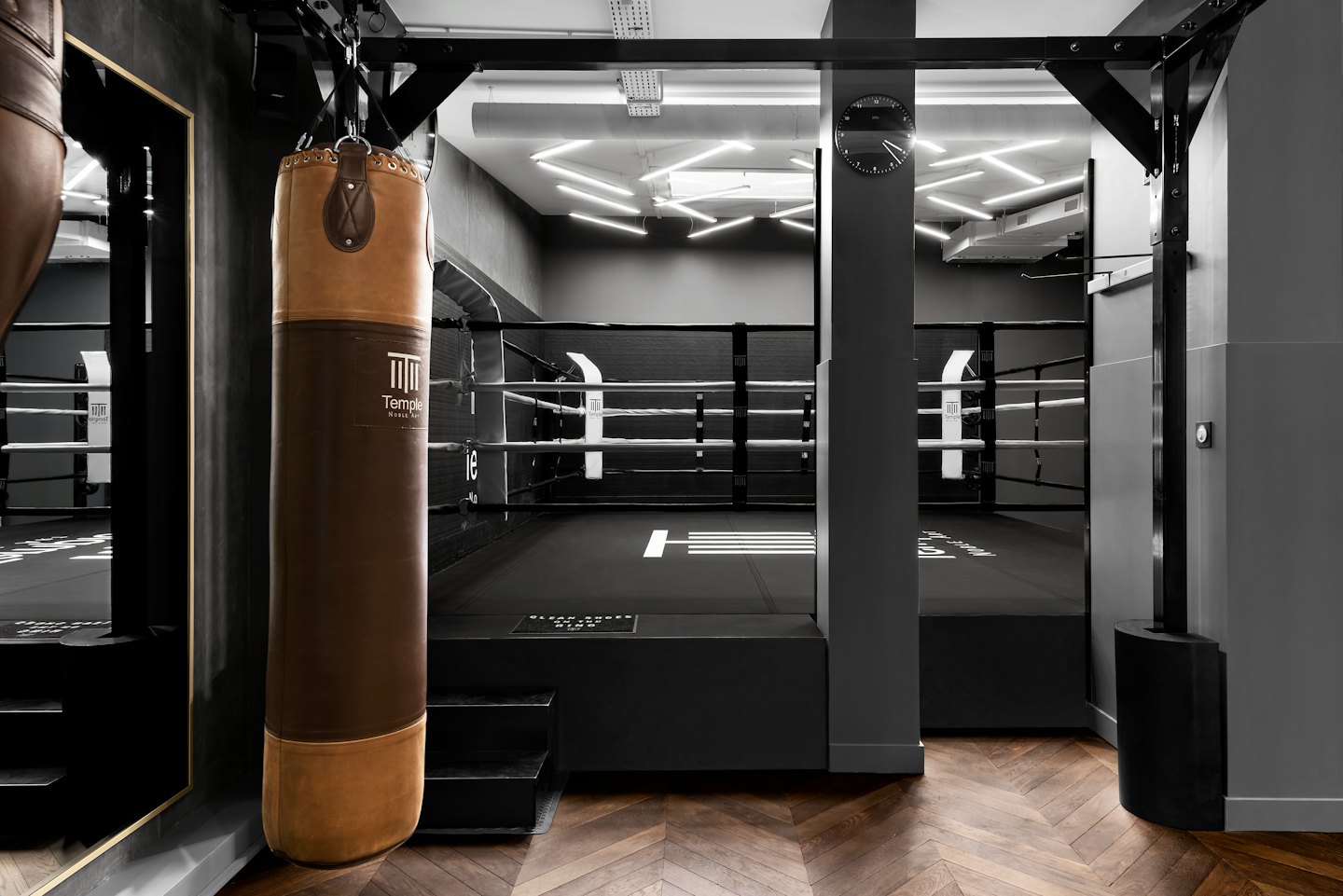 A boxing gym with a punching bag and boxing ring.