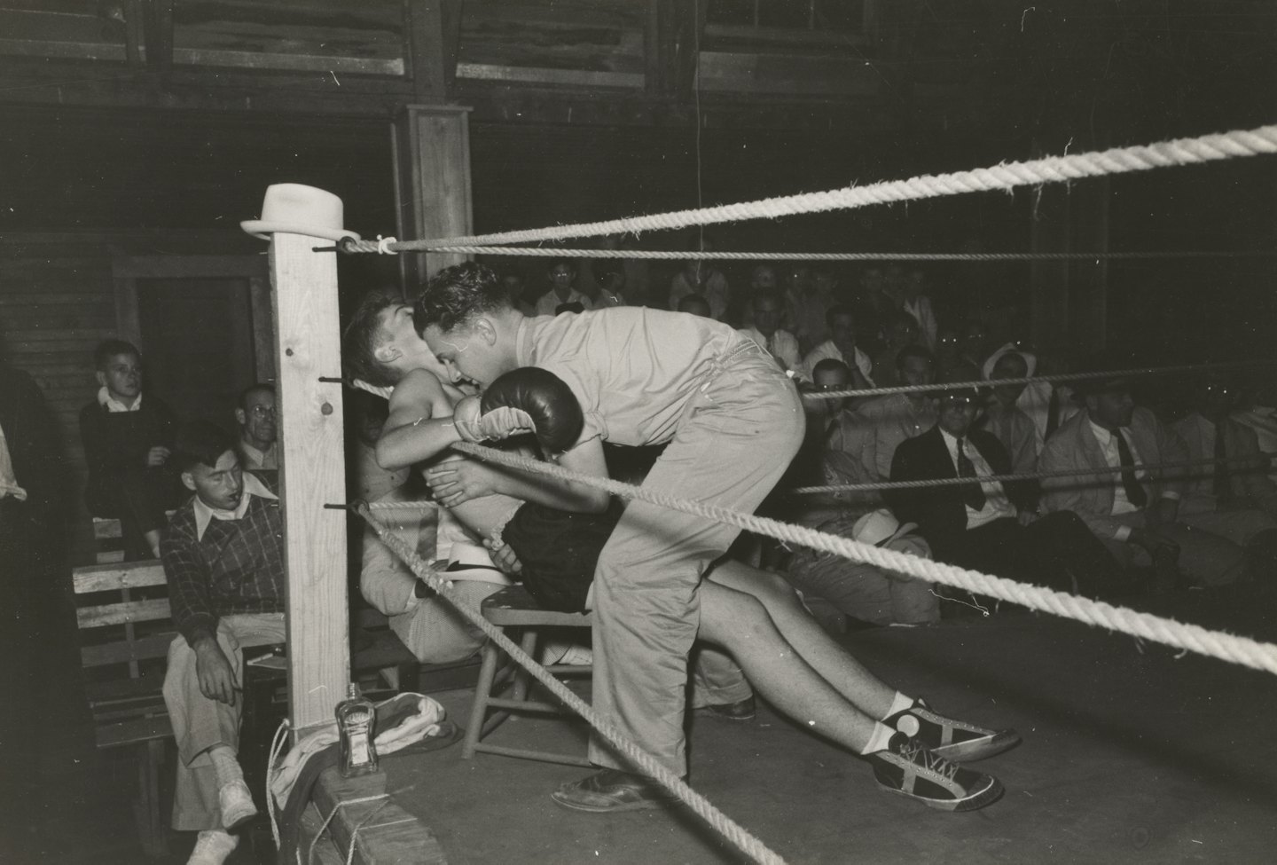 Boxing coach talks to boxer in corner of ring.
